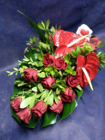 Rosas y anturium en la hoja de monstera en caja roja  44€